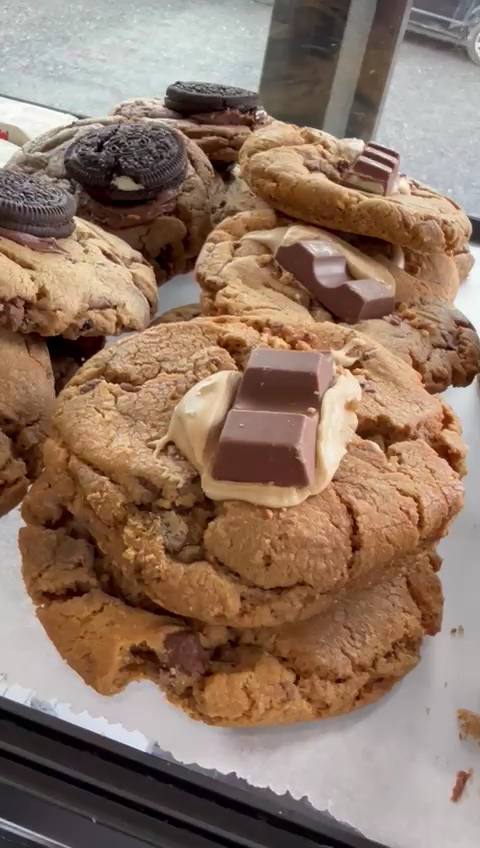 Assortment of large cookies topped with chocolate bars and Oreos